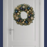 Haute Decor 24 Inch Sutton Place Christmas Wreath with Soft White LED Lights on Automatic Timer - Pre-Lit Christmas Wreath Featuring Blue and Gold Shatterproof Ornaments